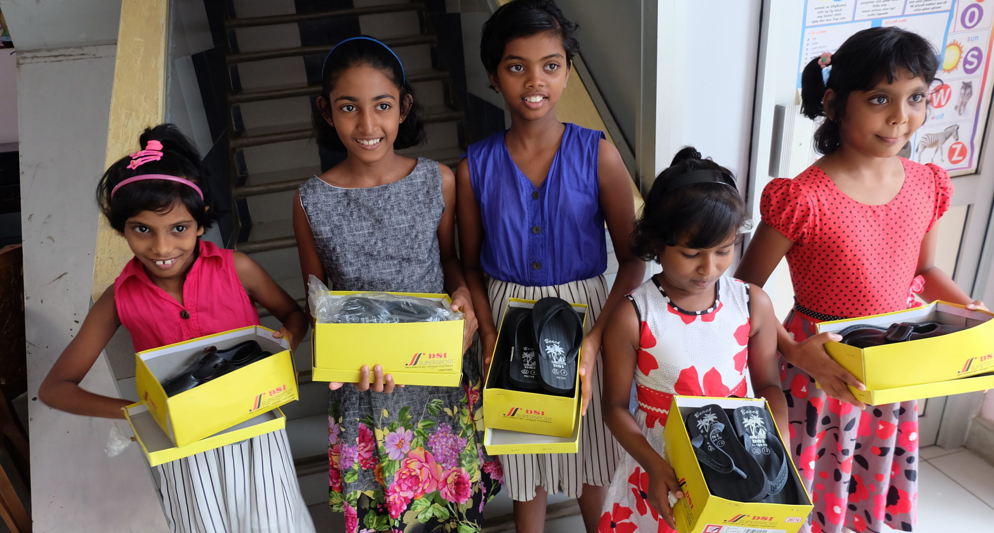 Image of children receiving shoes from our shoes and socks fund